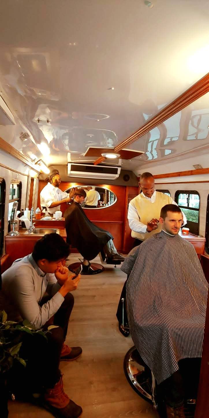 Interior of the Mobile Cuts studio with multiple barbers serving clients on-site