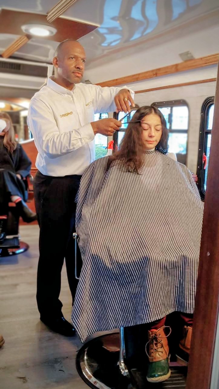 A Mobile Cuts client receiving a haircut inside the studio